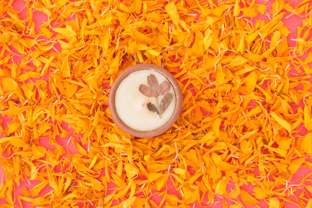 A Diwali candle on bright orange marigold petals - Foto, Bild