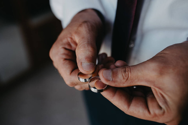 A man in a suit holding the wedding rings - Photo, Image