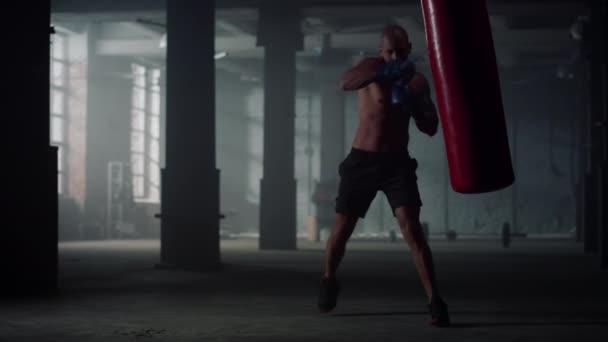 Férfi boxzsák a sportklubban. Agresszív srác rugdossa sporttáska - Felvétel, videó