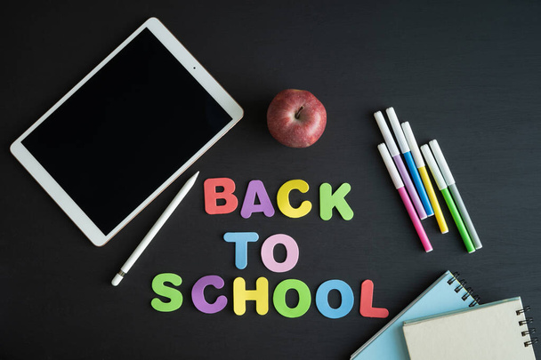 School materials with the phrase BACK TO SCHOOL on a black background. Copy space. - Photo, Image