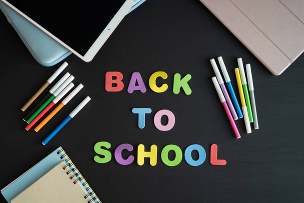 School materials with the phrase BACK TO SCHOOL on a black background. Copy space. - Photo, Image