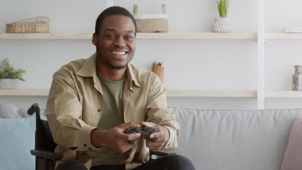 Vreugdevolle gehandicapte Afro-Amerikaanse man speelt en wint videogame binnen - Video