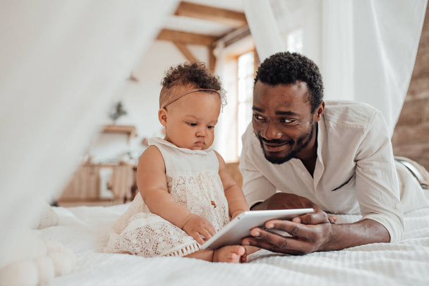 Vater-Baby-Verbindung. Glücklicher schwarzer Mann mit süßem Kleinkind zu Hause - Foto, Bild