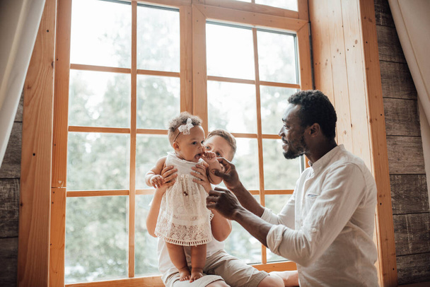 赤ちゃんの父親。自宅でかわいい幼児と幸せな黒人男性のボンディング.国際家族の概念 - 写真・画像