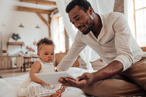 young black man and mixed race daughter with digital tablet  - Fotó, kép