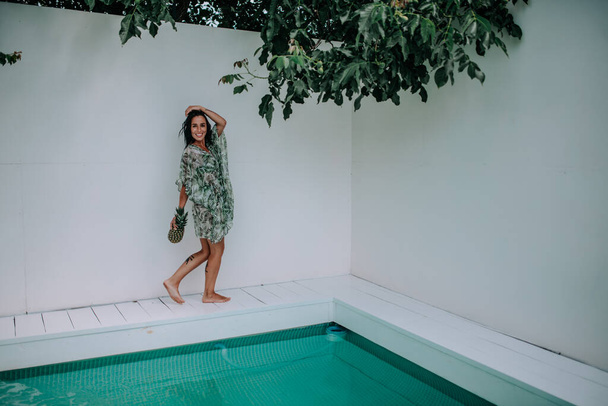Model posiert mit Ananas in Schwimmbadnähe  - Foto, Bild