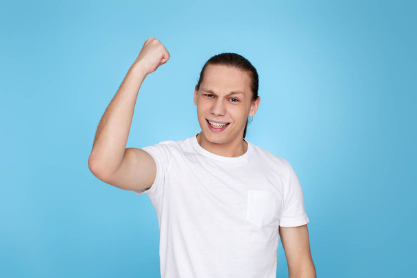 young handsome man in t-shirt showing victory gesture - Fotó, kép