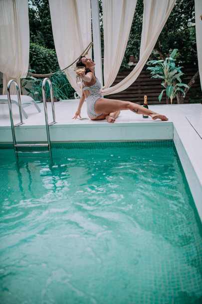 молодая женщина отдыхает у бассейна - Фото, изображение