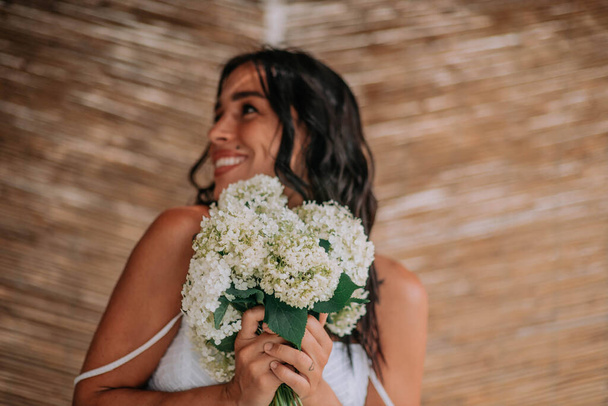 白いドレスを着た花嫁が花を持って  - 写真・画像