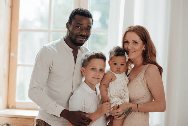 vreugdevol interraciaal paar met kinderen, familie portret  - Foto, afbeelding