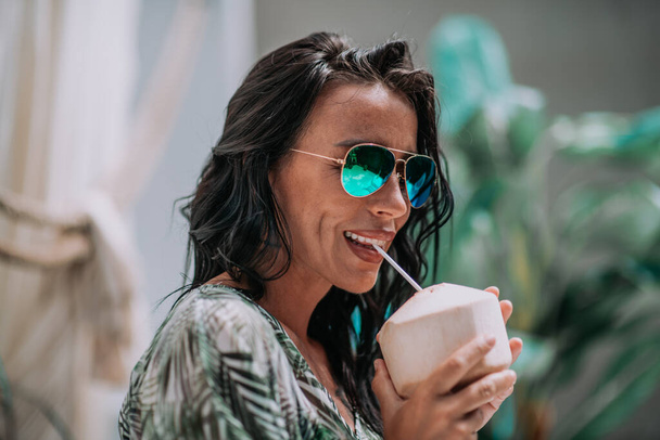 donna elegante in occhiali da sole con cocktail in mano - Foto, immagini