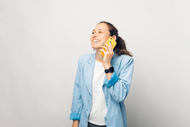 Retrato de mulher de negócios alegre falando em seu telefone celular sobre fundo branco - Foto, Imagem
