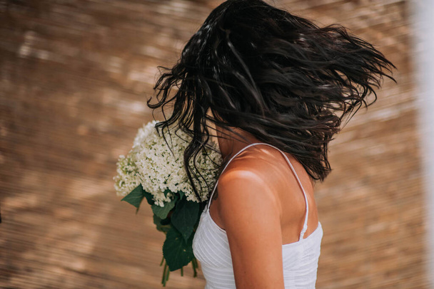 cropped image of bride in white dress with white flowers  - Zdjęcie, obraz