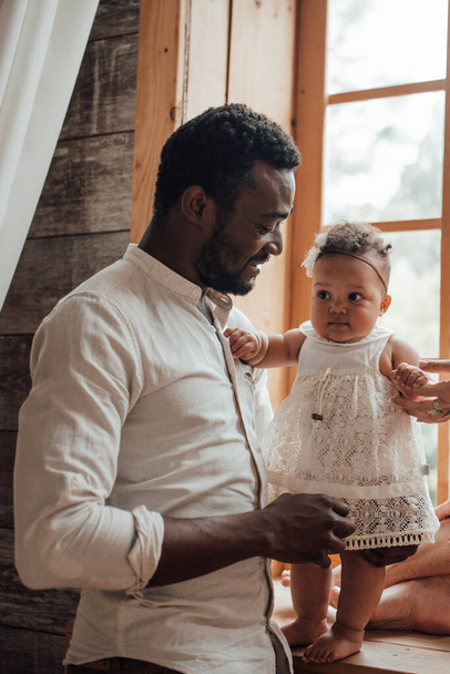 Батька дитячого зв'язку. Щасливий чорний чоловік з милою дитиною вдома - Фото, зображення