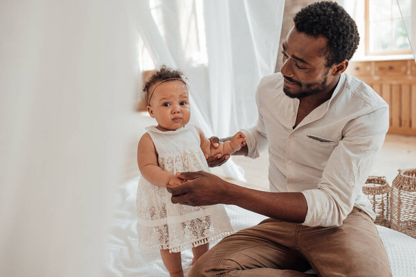 赤ちゃんの父親。幸せな黒男ボンディングでかわいい幼児とともに自宅 - 写真・画像