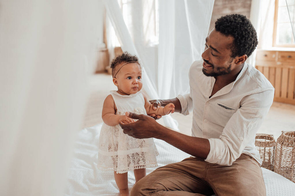 Spojení s otcem. Šťastný černošky muž spojení s roztomilé dítě doma - Fotografie, Obrázek