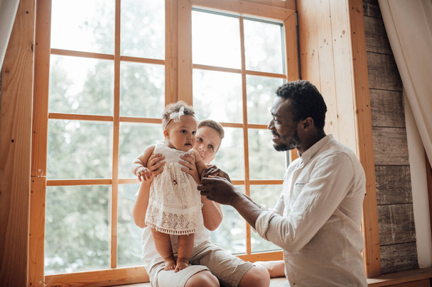 Baba Apuka kapcsolat. Boldog fekete férfi kötődik aranyos csecsemő gyermek otthon. Nemzetközi családi fogalom - Fotó, kép