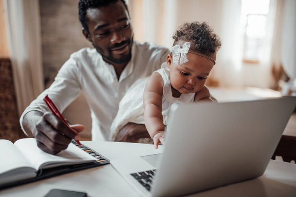 father working from home with daughter on hands - Fotografie, Obrázek