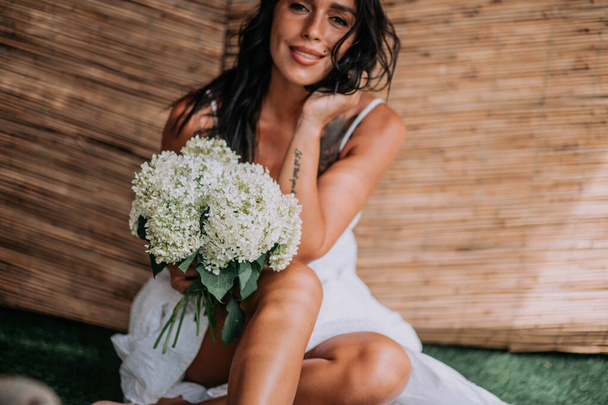 atraktivní dáma v šatech s bílou kyticí květin  - Fotografie, Obrázek