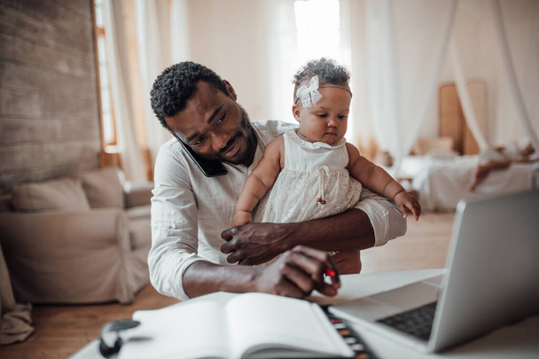 father working from home with daughter on hands - Photo, Image