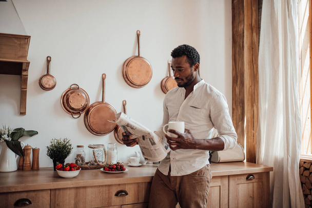 Afričan Američan v košili čtení novin a pití kávy - Fotografie, Obrázek