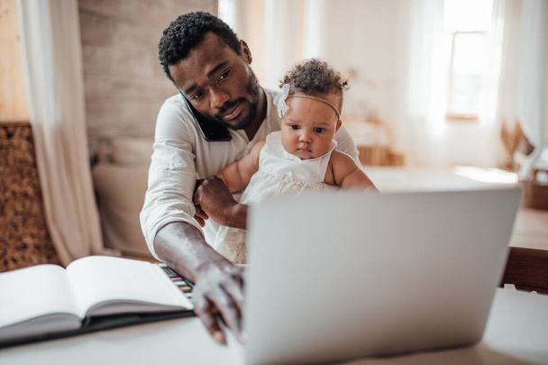 father working from home with daughter on hands - Φωτογραφία, εικόνα