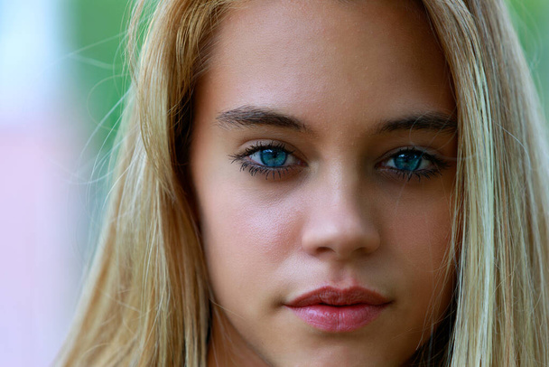 outdoor portrait of young blonde woman with intense gaze, natural background - Photo, image