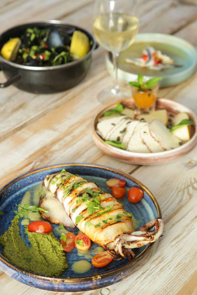 Vista superior sobre la mesa llena de platos de mariscos y verduras servidos - Foto, Imagen