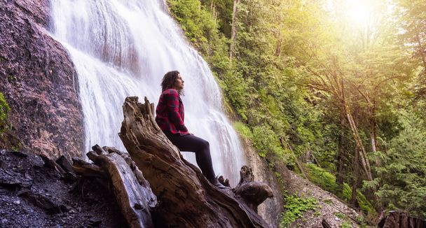 Woman watching the Waterfall in the Canadian rainforest. - Фото, зображення