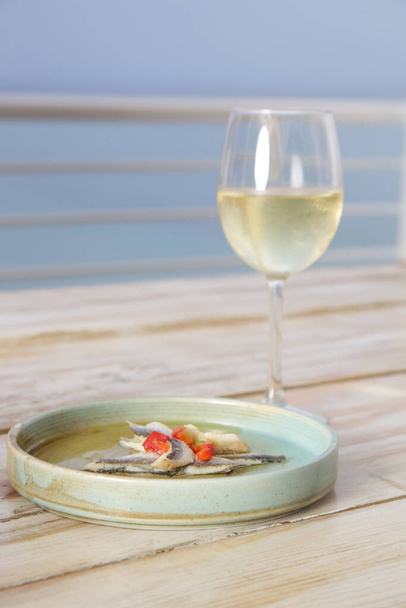 Μαριναρισμένες αντζούγιες και λευκό κρασί σερβίρονται στο τραπέζι του εστιατορίου. Gourmet εστιατόριο ιταλικό φαγητό. - Φωτογραφία, εικόνα