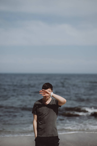 Hombre guapo posando sobre un fondo de mar - Foto, imagen