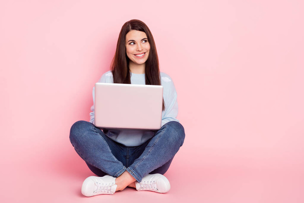 Full size photo of young happy smiling dreamy girl look copyspace sit floor work in laptop isolated on pink color background - Φωτογραφία, εικόνα