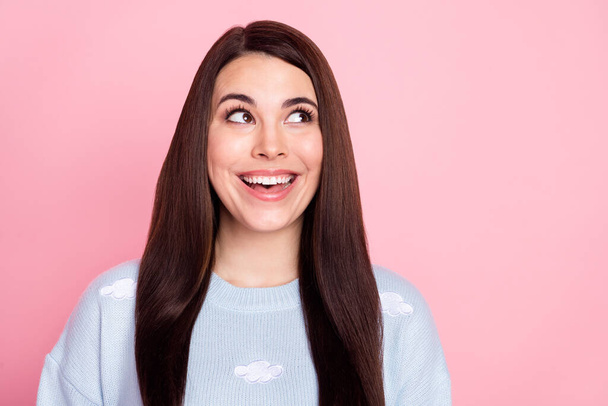 Photo of tricky funny young lady dressed blue sweater smiling looking empty space isolated pink color background - Фото, зображення