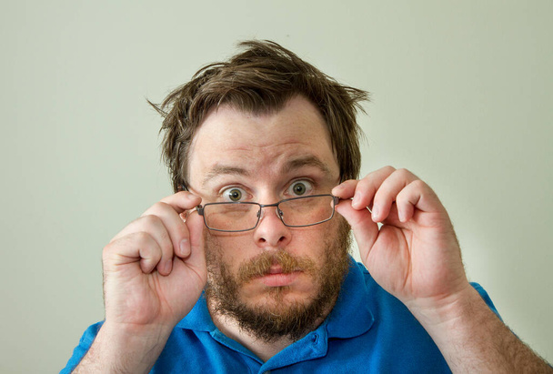 niet zeker over wat hij ziet een man verwijdert zijn bril - Foto, afbeelding