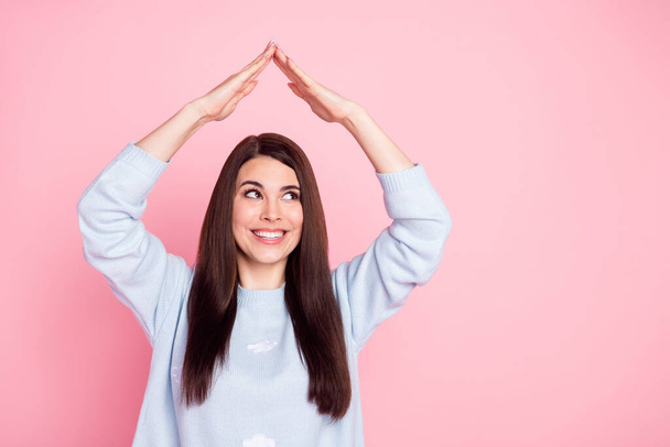 Photo of nice optimistic long hairdo brunette lady show roof look empty space wear blue sweater isolated on pink color background - Фото, изображение