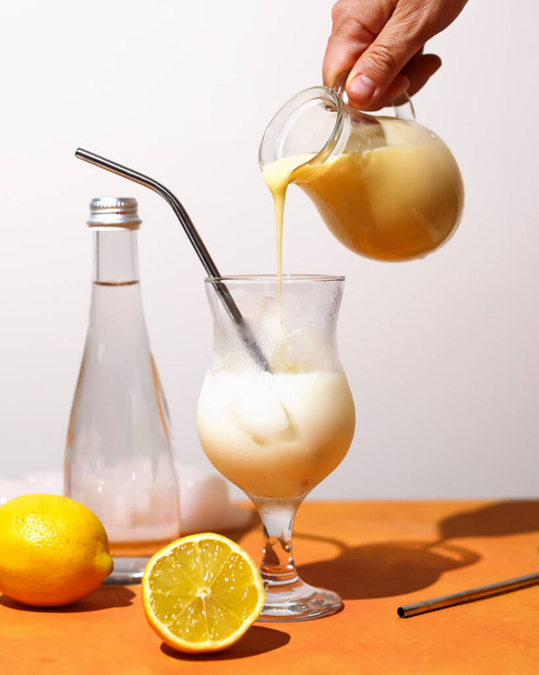 Krémes limonádés trendi nyári koktél. Hideg alkoholmentes koktél citromlével és édesített sűrített tejjel. Hozzávalók a finom italok elkészítéséhez. - Fotó, kép