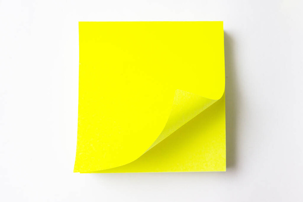 Gelbes, klebriges Papier mit gerollt auf weißem Hintergrund. - Foto, Bild