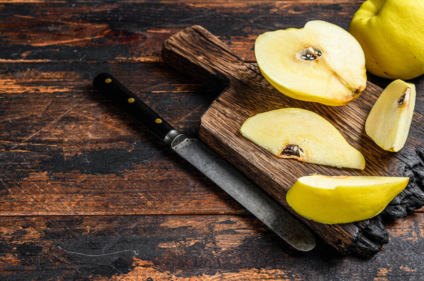 Frutas de membrillo de oro fresco en una tabla de cortar. Fondo de madera oscura. Vista superior. Copiar espacio - Foto, Imagen