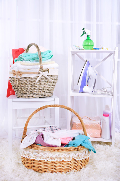Colorful towels and clothes in baskets on table - Фото, изображение
