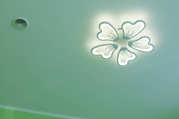 Sufit z żyrandoliem LED i wentylacją. Dekoracyjny żyrandol LED w postaci kwiatu pod sufitem. Zbliżenie - Zdjęcie, obraz