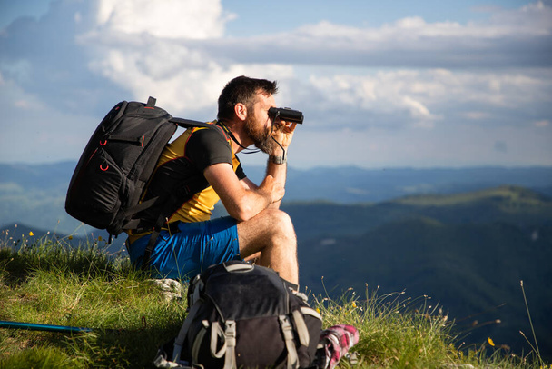 jóképű férfi túrázás a természetben távcsővel lassú utazás - Fotó, kép
