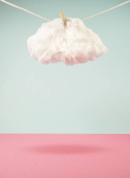 Cloud hanging from a rope casting shadow on a ground. Attached with wooden clip. Climate change idea. Minimal abstract weather concept. With copy space. - Photo, Image