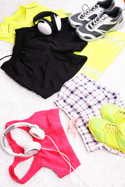 Sport clothes, shoes and headphones on white carpet background.  - Fotó, kép