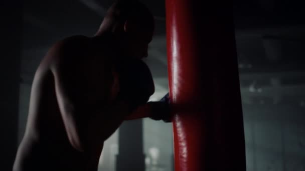 Afro-Boxer schlägt Boxsack. Sportler trainiert Schläge im Fitnessstudio - Filmmaterial, Video
