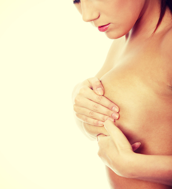 Young caucasian adult woman examining her breast - Foto, Imagen