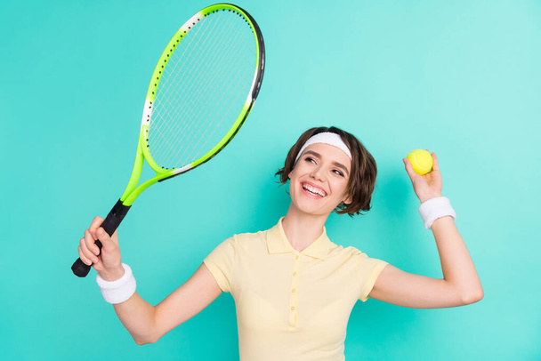 Photo of attractive happy young tennis player woman hold racket ball serve isolated on pastel teal color background - Photo, Image