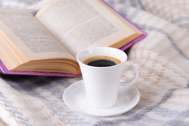 Cup of coffee on plaid with book - Фото, зображення