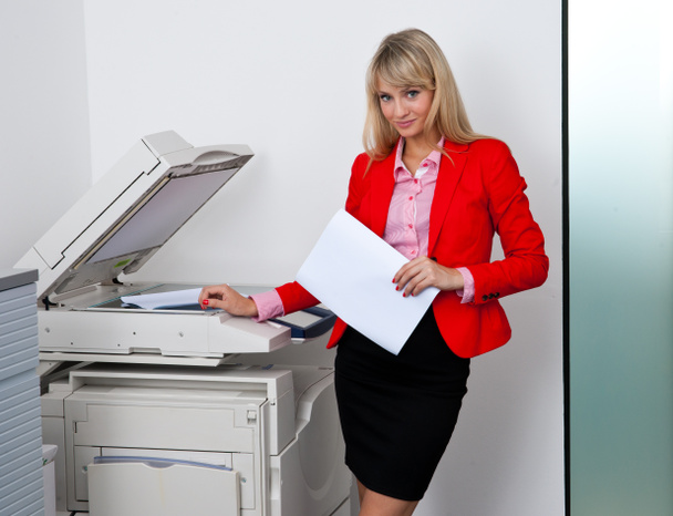 ビジネスの女性のオフィスのプリンターに取り組んで - 写真・画像