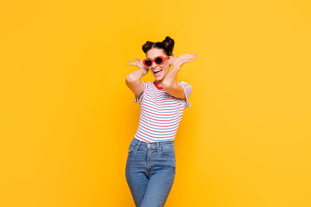 Photo of sweet funny young lady dressed striped outfit dark eyewear dancing arms ears isolated yellow color background - Φωτογραφία, εικόνα