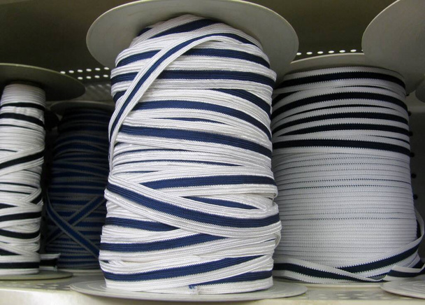 Λευκά και ναυτικά μπλε τελειώματα σχοινιά σε πηνία σε ράφι - Φωτογραφία, εικόνα